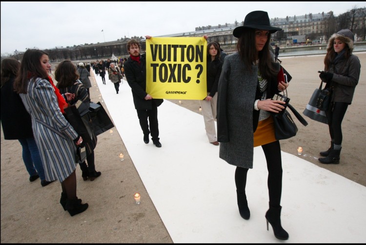 Greenpeace activists follow one of the attendants at the Paris Fashion Week in 2013
