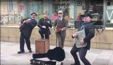 Four men dressed in suits busking