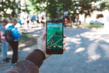 Player holds up smartphone with Pokémon Go