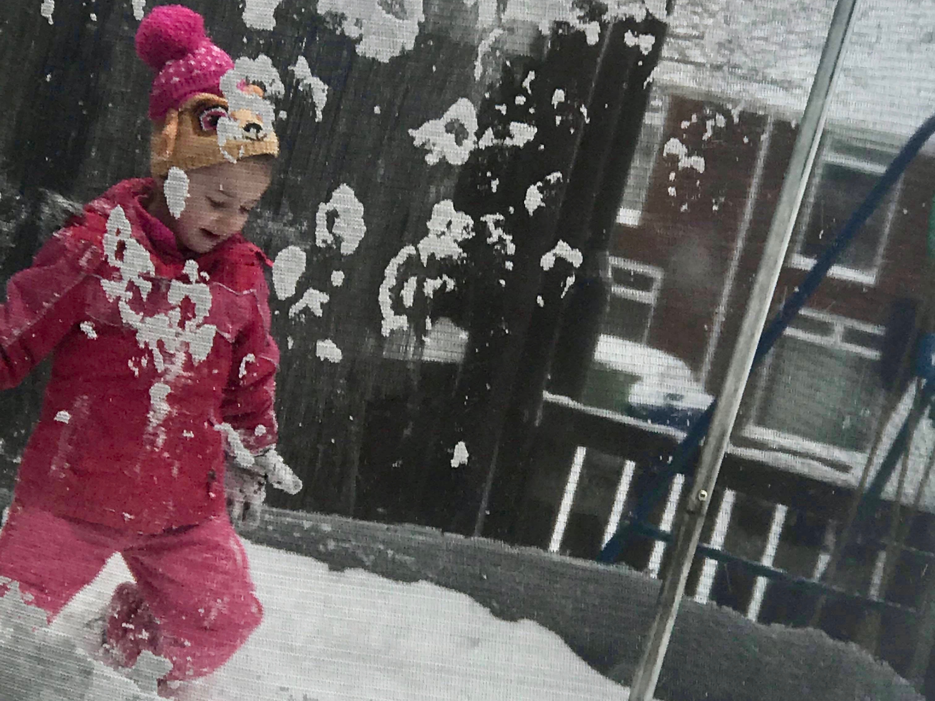 A young girl plays on a trampoline in the snow